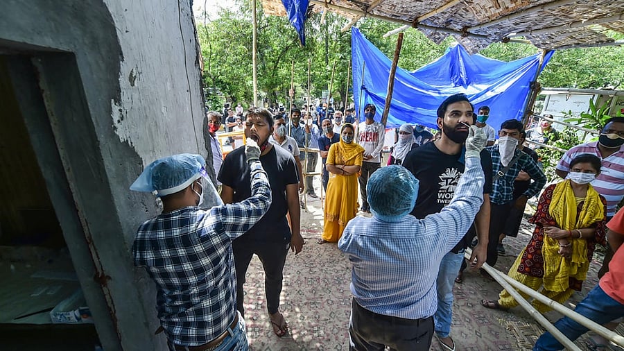  People stand in queue for Covid-19 testing, amid the rise in Covid-19 cases across the country, in Ghaziabad. Credit: PTI Photo