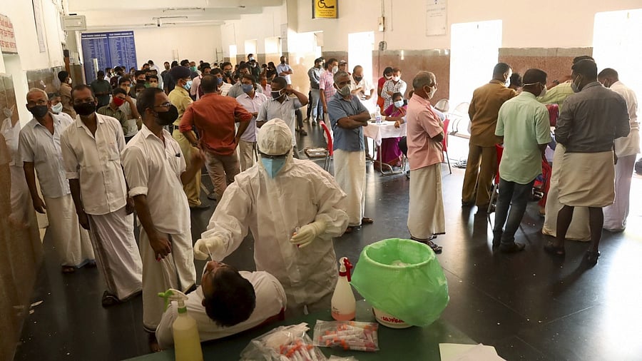 People wait to undergo Covid-19 testing at a railway station during Covid-induced lockdown in Kozhikode. Credit: PTI Photo