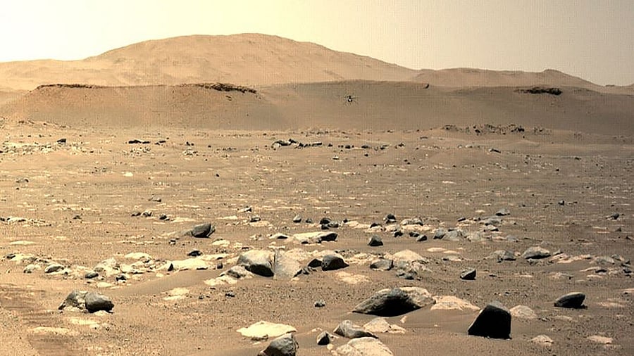 This NASA photo shows NASA's Ingenuity Mars Helicopter(C) seen hovering during its third flight on April 25, 2021, as seen by the left Navigation Camera aboard NASA's Perseverance Mars Rover. Credit: AFP Photo