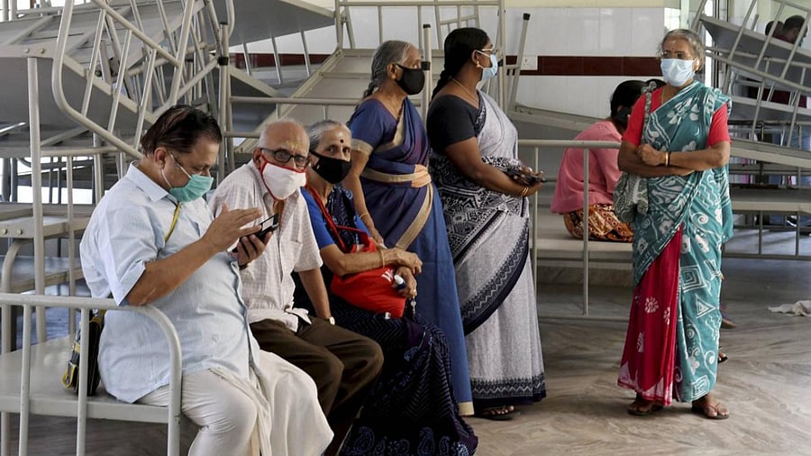 People wait to receive a dose of COVID-19 vaccine at the Government Homeopathic Medical College Hospital in Iranimuttom. Credit: PTI photo.