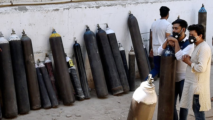 Relatives of Covid-19 patients wait to refill cylinders with medical oxygen at Badarpur during the second wave of Covid-19 pandemic in New Delhi. Credit: PTI Photo
