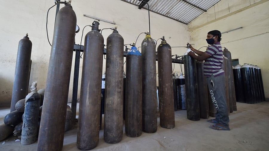 A worker sorts cylinders with medical oxygen at Badarpur during the second wave of coronavirus pandemic in India, in New Delhi. Credit: PTI Photo