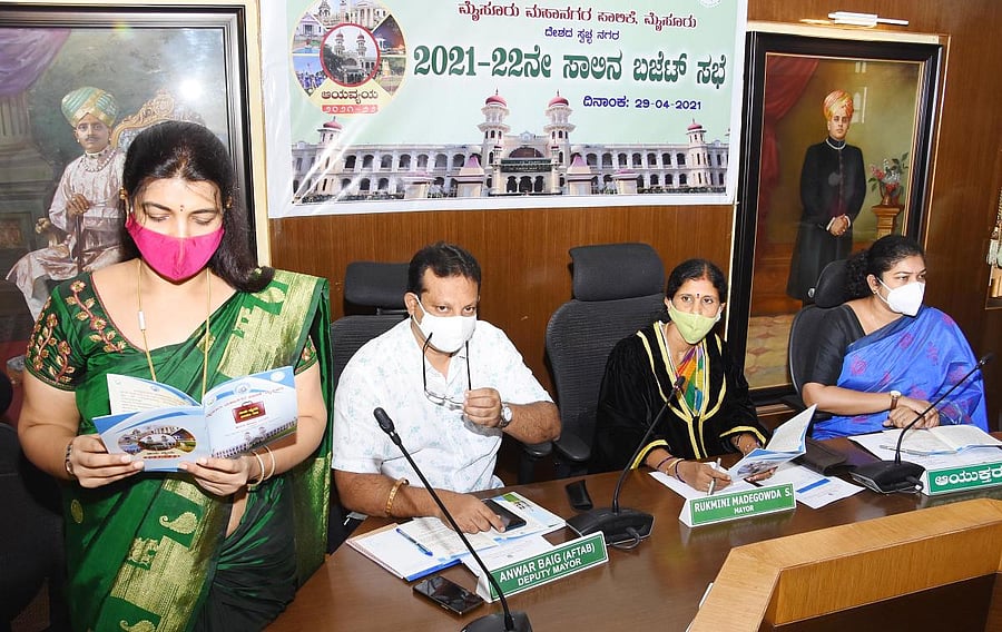 Chairperson of the Tax, Finance and Appeals Standing Committee M S Shobha presents the budget for the financial year 2021-22, at Mysuru City Corporation in Mysuru on Thursday. Deputy Mayor Anwar Baig, Mayor Rukmini Madegowda and MCC Commissioner Shilpa Nag are seen. DH Photo