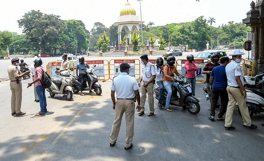 The city police intercept motorists during the Covid curfew at Hardinge Circle in Mysuru on Thursday. DH Photo