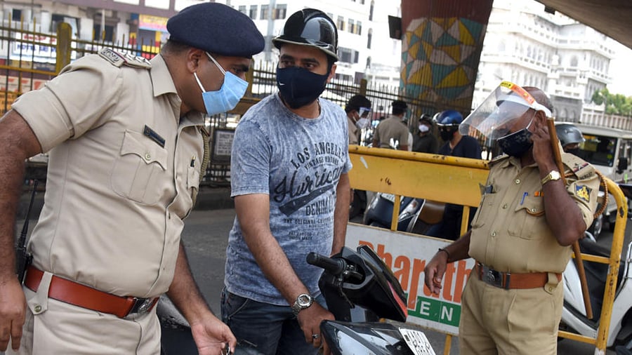 A policeman snatching away the keys from a rider at KR Market. DH FILE/S K Dinesh