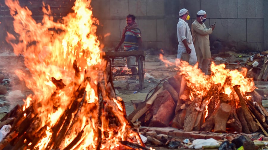  People belonging to Muslim community help in cremation of their friend's relative who died at his residence, at Old Seemapuri Cremation Grounds in New Delhi , Sunday, May 2, 2021. credit: PTI Photo