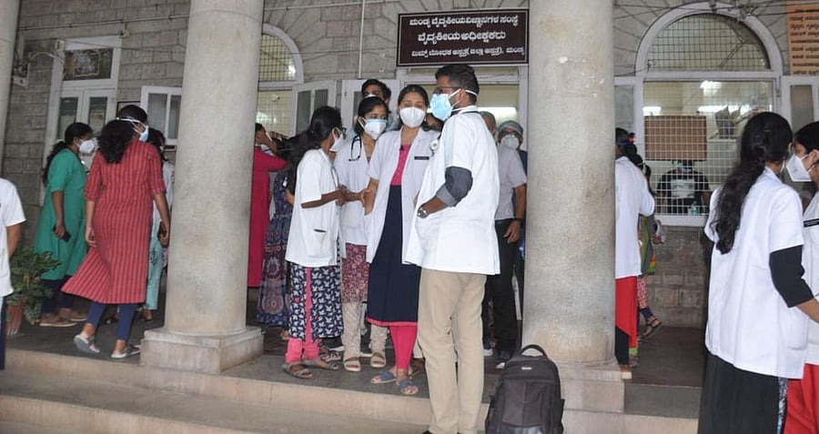 Postgraduate students gather near the MIMS director's office to lodge a complaint against the attack on a doctor in the Covid ward in Mandya on Tuesday. Credit: DH Photo