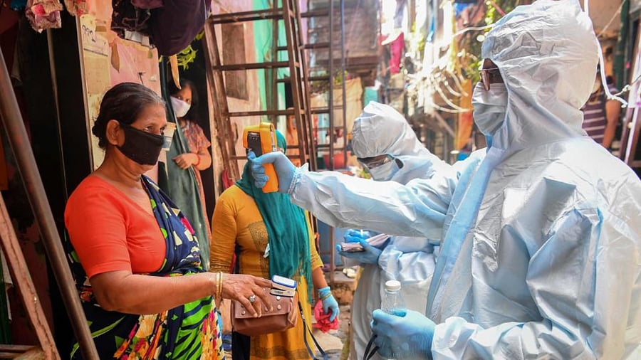 Medical staff wearing personal protective equipment (PPE) conduct a door-to-door medical screening inside the Dharavi slums to fight against the spread of coronavirus in Mumbai.  Credit: AFP File Photo