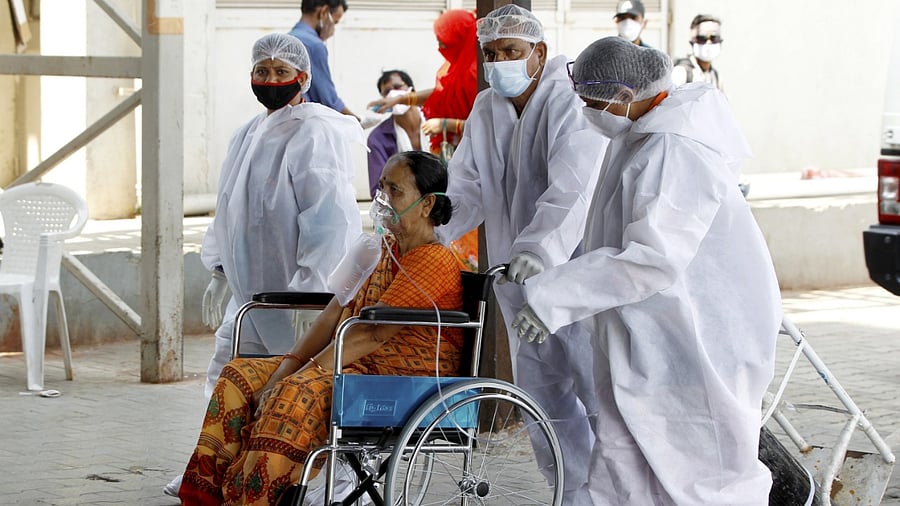 Health workers move a Covid-19 patient to the Coronavirus OPD at Government Covid-19 hospital, in Ahmedabad, Tuesday, May 4, 2021. Representative Image. Credit: PTI File Photo