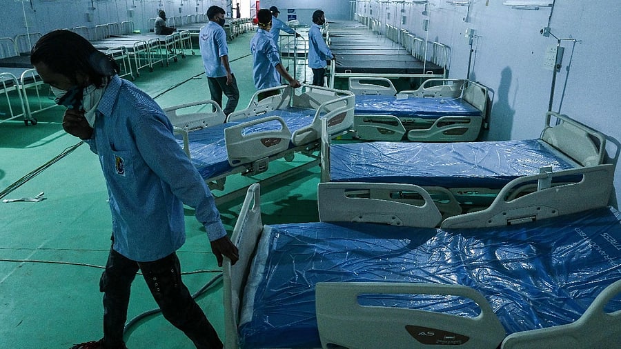 Volunteers arrange beds for patients at the Ramleela Maidan ground temporarily converted into a Covid-19 coronavirus care centre, in New Delhi. Credit: AFP Photo