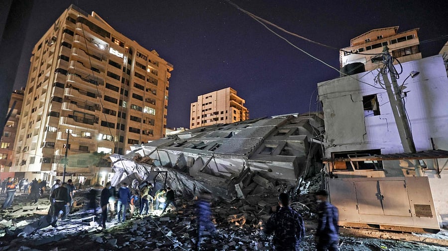 People gather at the site of a collapsed building in the aftermath of Israeli air strikes on Gaza City. Credit: AFP Photo