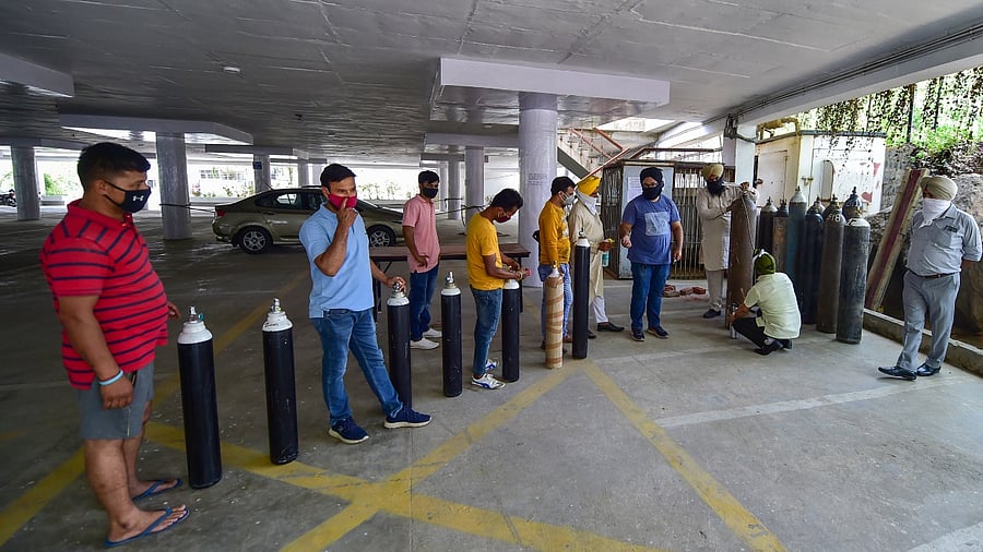 Volunteers refill oxygen cylinders for Covid-19 patients, at Gurudwara Singh Sabha in Greater Kailash, New Delhi. Credit: PTI Photo
