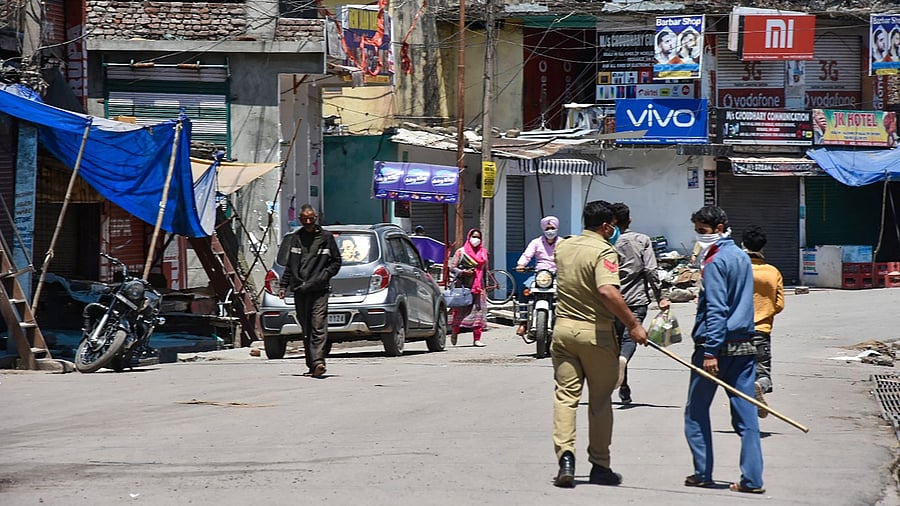 A policeman chases a violator of Covid-19 lockdown norms in Poonch, Wednesday, May 12, 2021. Credit: PTI Photo