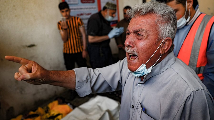 The grandfather of three children from the Al-Tanani family, killed in a reported Israeli air strike, reacts at family residence before their burial in Beit Lahya in northern Gaza strip, on May 14, 2021. Credit: AFP Photo