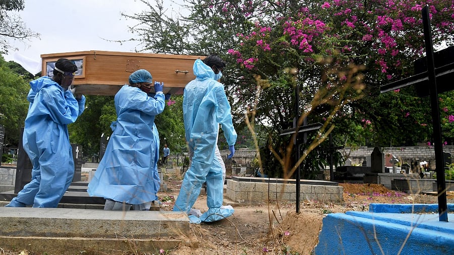 Volunteers of Mercy Angels and Archdiocese of Bangalore carry a Covid-19 victim for burial at Indian Christian Cemetery, Bengaluru. Credit: DH File Photo/Pushkar V