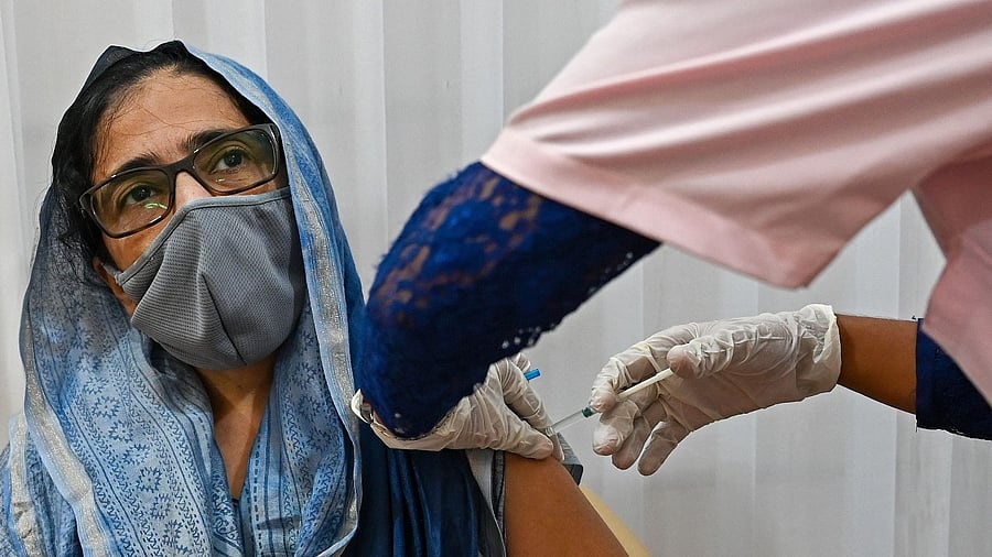 A woman gets inoculated with the Covid-19 vaccine at a vaccination center in Mumbai. Credit: AFP File Photo