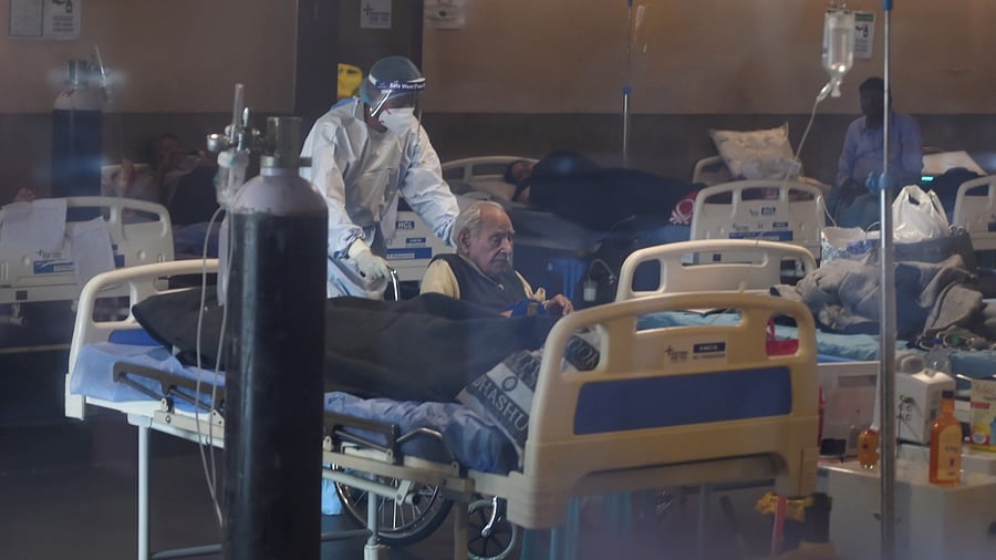 Health workers attend Covid-19 patients undergoing treatment at Shehnai Banquet Hall isolation centre, in New Delhi, Monday, May 17, 2021. Credit: PTI Photo