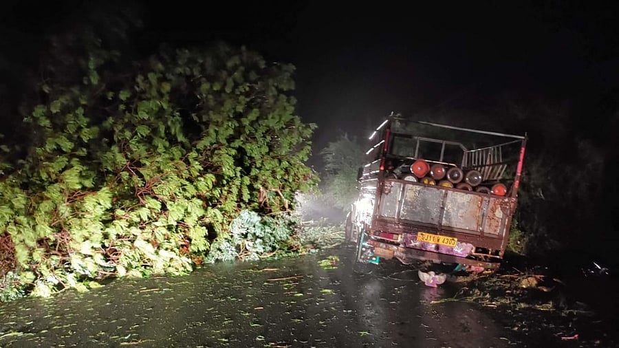 A truck loaded with oxygen cylinders stuck as trees fell due to impact of approaching Cyclone Tauktae, near Mahua, some 300 kms from Ahmedabad. Credit: AFP Photo