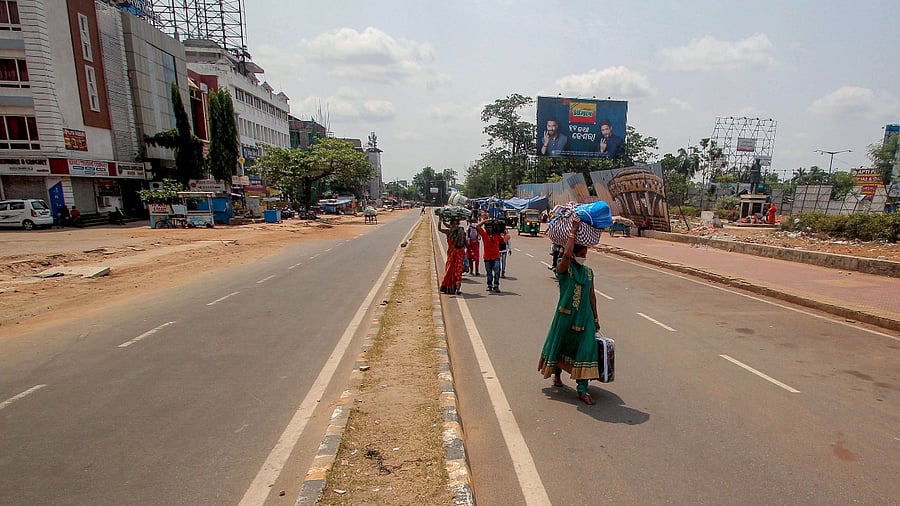 Migrants walk during Covid induced statewide 14-day lockdown in the wake of rising coronavirus cases, in Bhubaneswar, Wednesday, May 5, 2021. Credit: PTI Photo