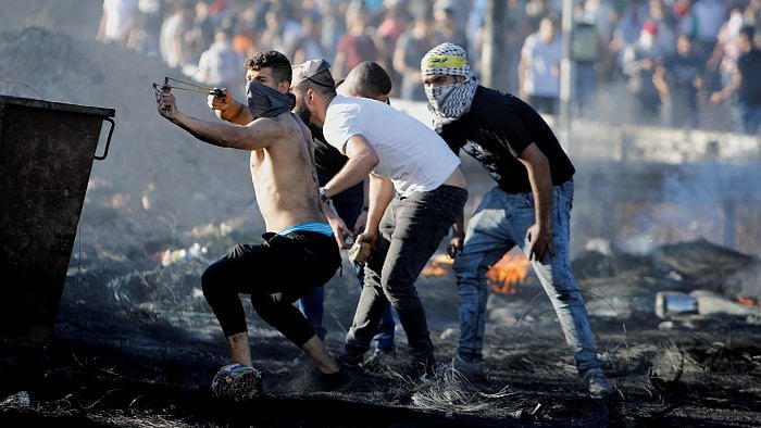 A Palestinian uses a slingshot during an anti-Israel protest over a cross-border violence between Palestinian militants in Gaza and the Israeli military, near Hawara checkpoint near Nablus in the Israeli-occupied West Bank. Credit: Reuters Photo