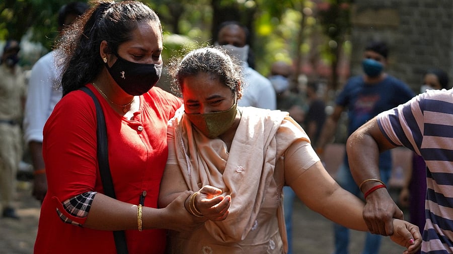Sagayadayana Amalraj Barnabas, wife of Amal Raj, who died in a barge that sank in the Arabian Sea following Cyclone Tauktae, is consoled by her relatives at a hospital in Mumbai. Credit: Reuters Photo