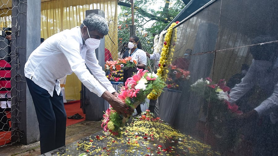 District-in-charge minister Kota Srinivas Poojary places a wreath at the Mangaluru air crash memorial site in Kuloor-Thannirubhavi on Saturday. Credit: DH Photo