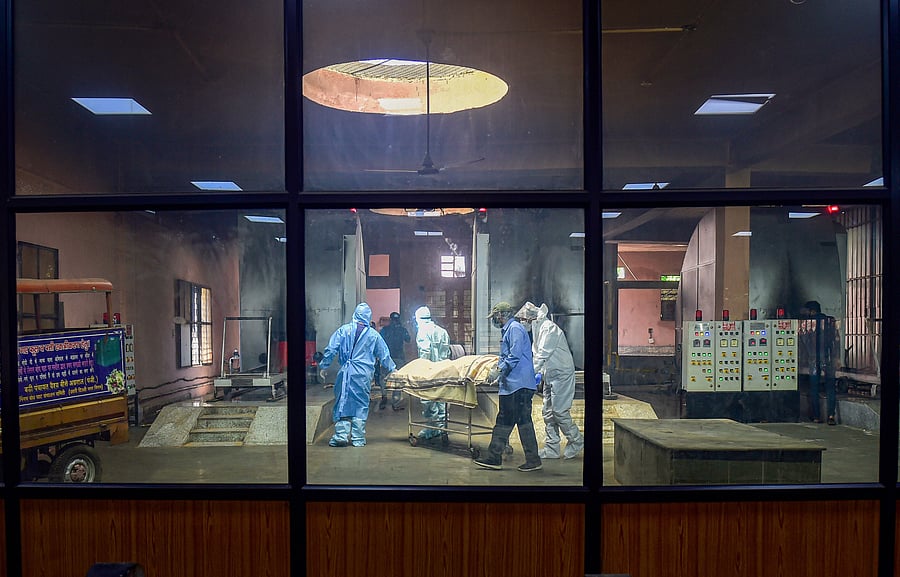  Family members prepare to cremate a COVID-19 victim at Nigambodh Ghat cremation ground, in New Delhi. Credit: PTI