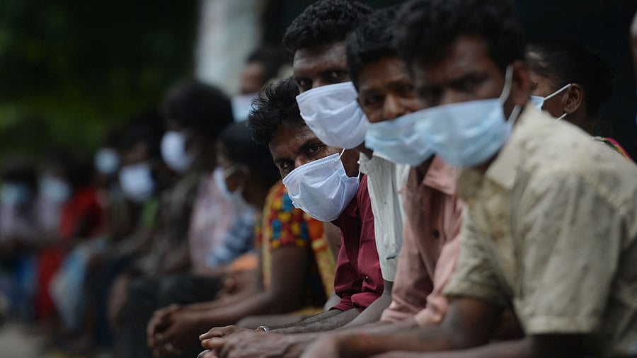 People wait to receive a meal distributed by an humanitarian organisation during a complete lockdown imposed by the the state government as a preventive measure against the spread of the Covid-19 coronavirus in Chennai on May 25, 2021. Credit: AFP Photo