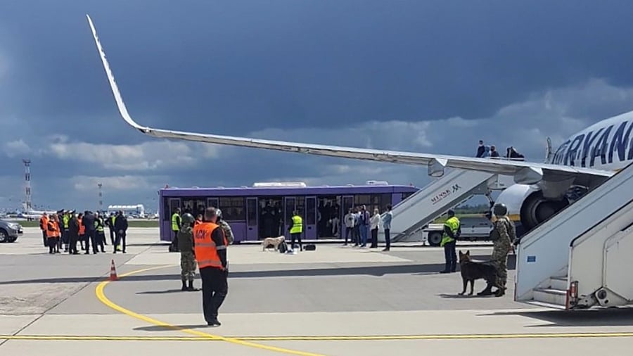Airport personnel and security forces are seen on the tarmac in front of a Ryanair flight which was forced to land in Minsk. Credit: Reuters Photo/handout
