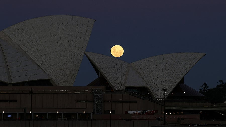 A Super Flower Moon rises behind the Sydney Opera House on the night of a lunar eclipse. Credit: Reuters Photo