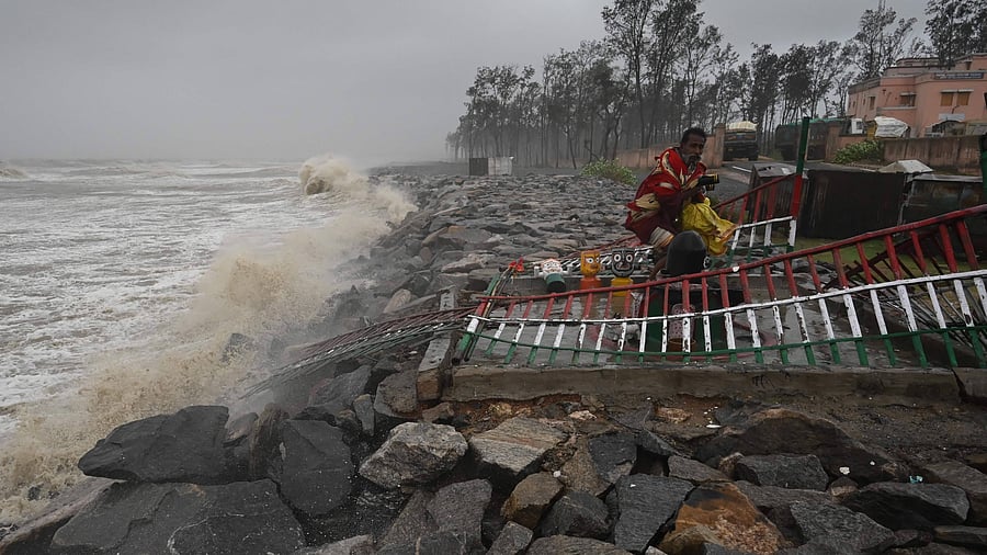 A Hindu priest removes an idol of Lord Jagannath from a seafront temple to a safer place, in Balasore district in Odisha. Credit: AFP Photo