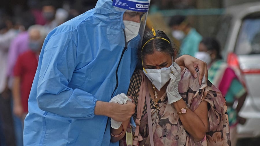 A relative of a Covid victim being consoled in Bengaluru on Wednesday. Credit: DH photo/Irshad Mohammed