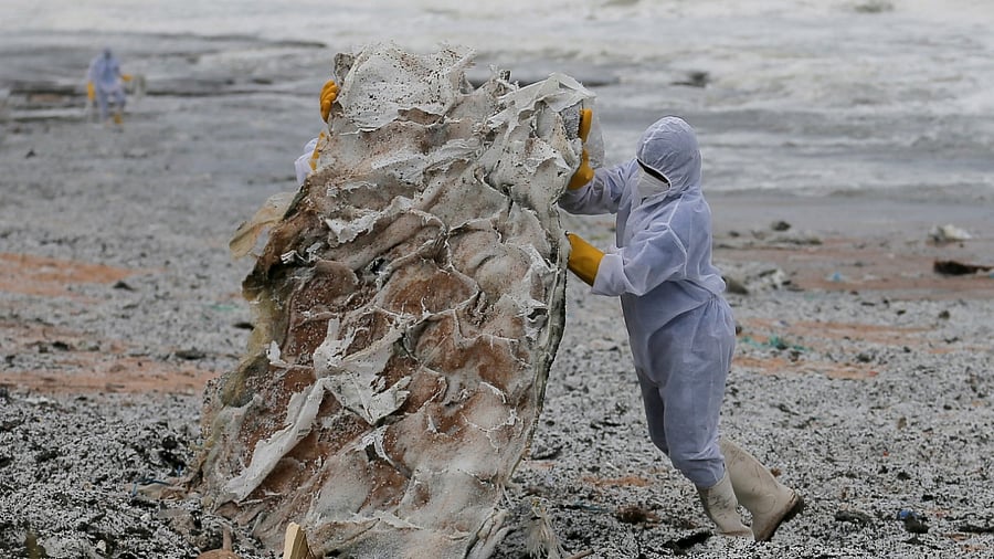 Sri Lankan Navy members push the debris washed off to a beach from the MV X-Press Pearl container ship which caught fire off the Colombo Harbour, in Ja-Ela, Sri Lanka. Credit: Reuters Photo