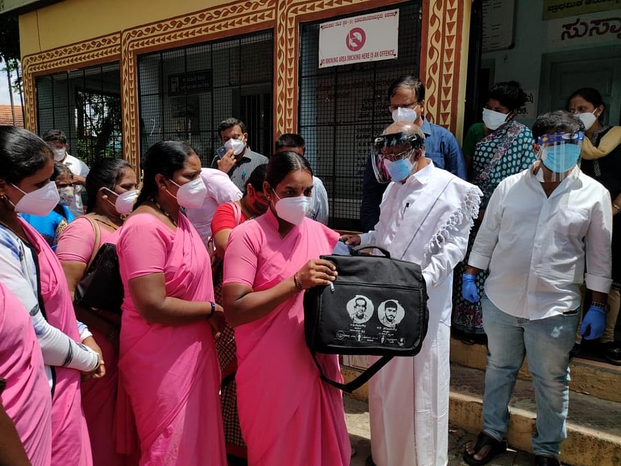MLA G T Devegowda distributes medical kits to Asha volunteers at Sagarkatte Primary Health Centre in Mysuru district recently. DH Photo