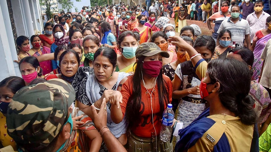 Police officers urge beneficiaries to maintain social distancing, as they wait in a queue to receive the Covid-19 vaccine dose at a vaccination centre, at Balurghat in South Dinajpur district, Friday, May 28, 2021. Credit: PTI Photo