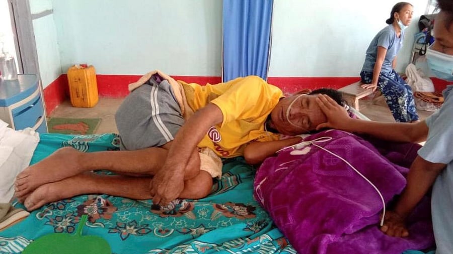 A coronavirus patient is comforted by a family member at the hospital in Cikha, Myanmar. Credit: Reuters Photo