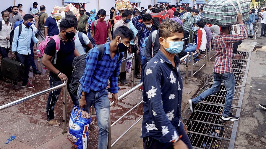 People gather at a railway station to head to their native places during weekend lockdown imposed by state authorities to curb the spread of coronavirus. Credit: PTI file photo