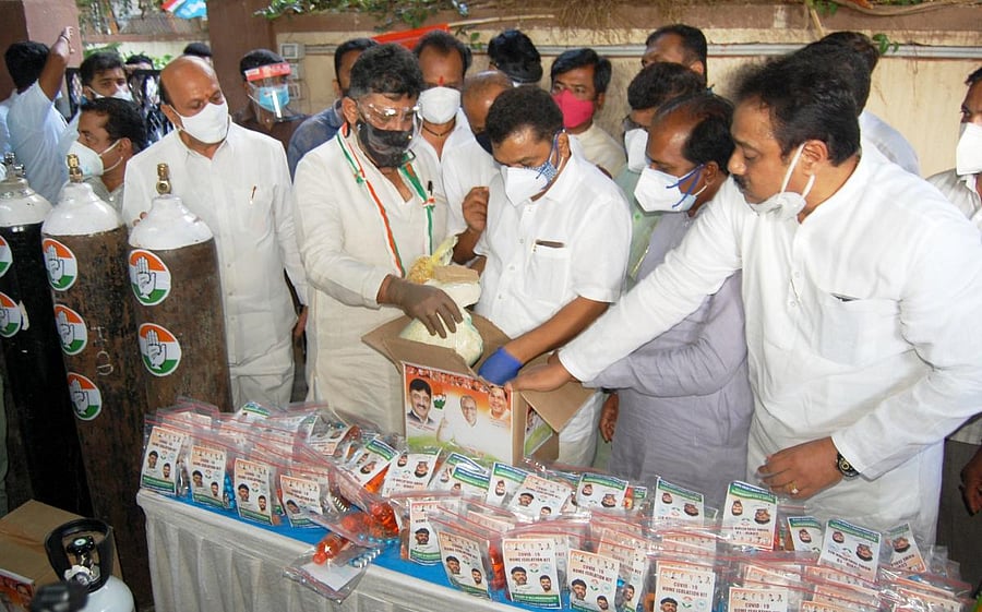 Karnataka Pradesh Congress Committee President D K Shivakumar looks at the 'relief package' kit, prepared by local Congress leaders for the needy persons, in Hubballi on Sunday. MLA Prasad Abbayya, and other leaders are seen. Credit: DH Photo