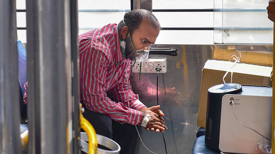 A Covid-19 patient on oxygen support inside the 'Oxygen on Wheels', a bus that reaches out to patients in immediate need of oxygen, in Bengaluru, Thursday, May 13, 2021. Credit: PTI Photo
