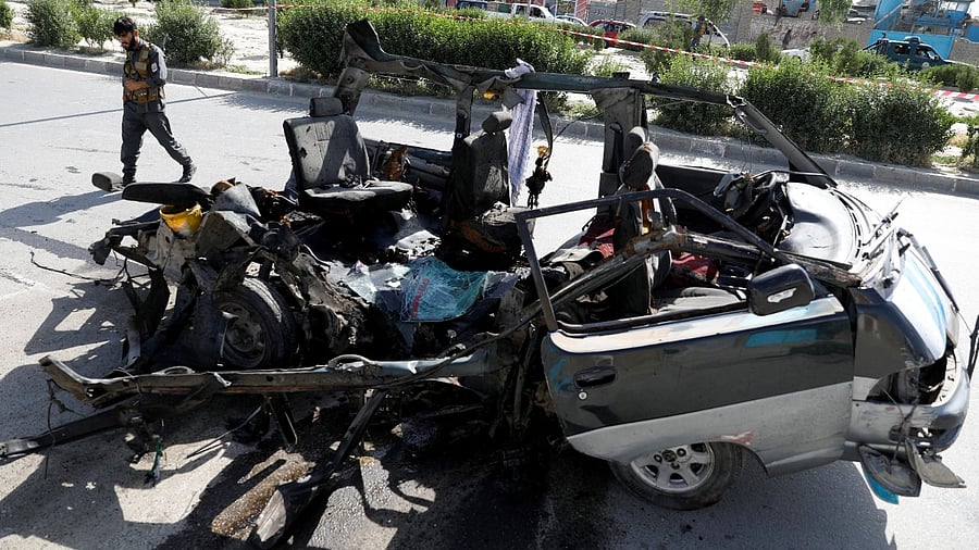 An Afghan police officer inspects a damaged van after a blast in Kabul, Afghanistan. Credit: Reuters Photo