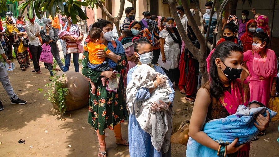 Women queue up outside the District Hospital to get their children vaccinated against various diseases, in Noida, Wednesday, June 2, 2021. Credit: PTI Photo