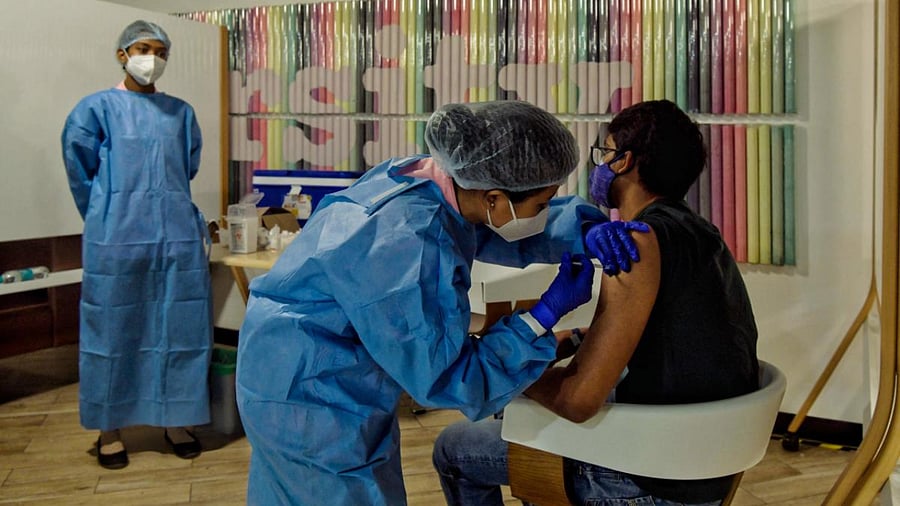 A health worker inoculates an Amazon employee with a dose of the Covishield vaccine in Bengaluru. Credit: AFP Photo