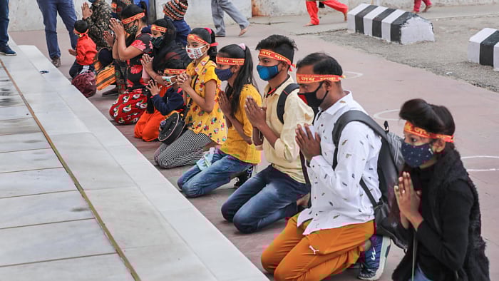 Pilgrims, wearing face masks, pray while on their way towards the cave shrine of Mata Vaishno Devi. Credit: PTI File Photo