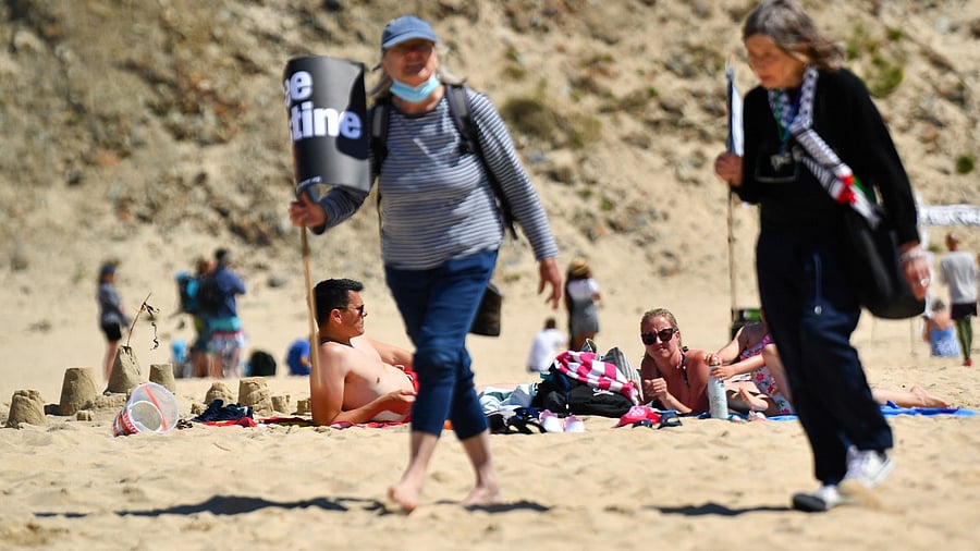Holidaymakers lay on the beach during a "Stop the War" and climate change activists protest, in Hayle, during the G7 summit, in Cornwall. Credit: Reuters photo