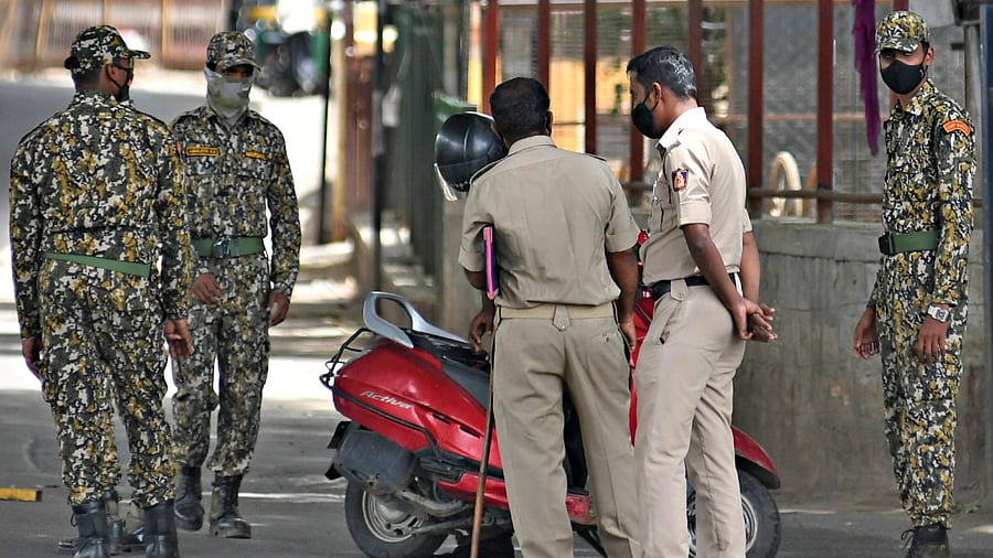 Police, BBMP marshals and civil defence personnel check commuters during the lockdown at KR Market in Bengaluru. Credit: DH Photo/Pushkar V