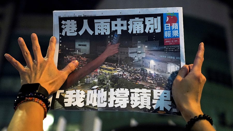 A supporter gestures while holding the final edition of Apple Daily in Hong Kong. Credit: Reuters photo