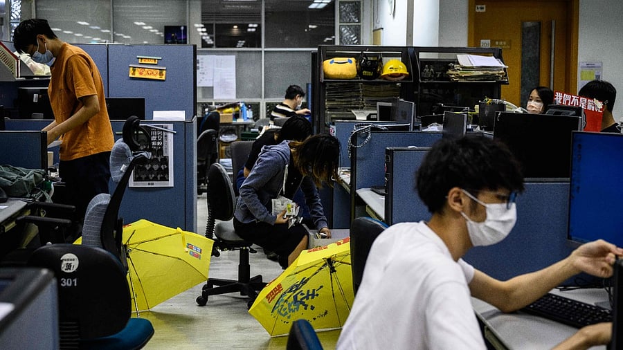 An employee (C) empties her desk drawers at the 'Apple Daily' newspaper offices in Hong Kong. Credit: AFP File Photo