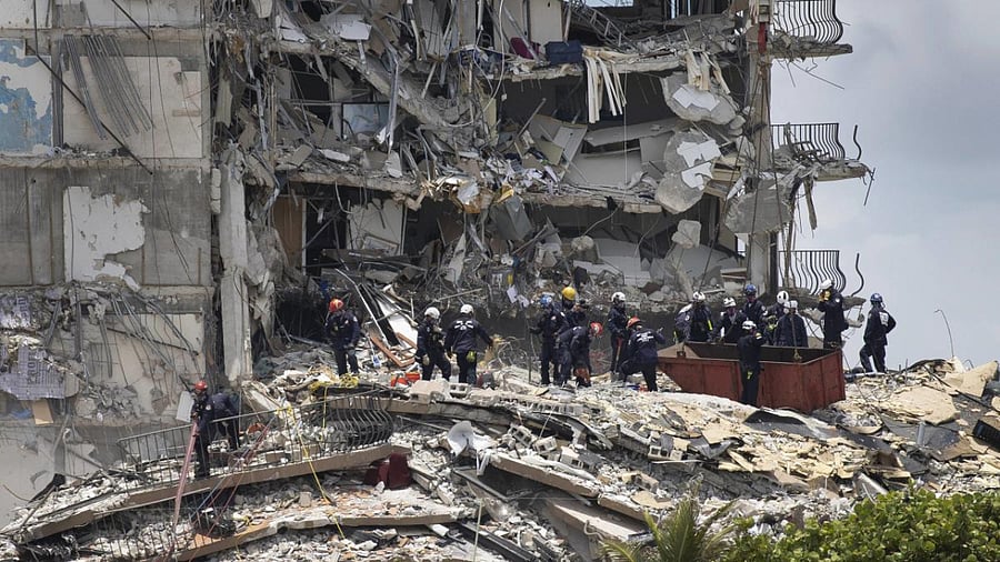 Members of the South Florida Urban Search and Rescue team look for possible survivors in the partially collapsed 12-story Champlain Towers South condo building on June 26, 2021 in Surfside, Florida. Credit: AFP Photo