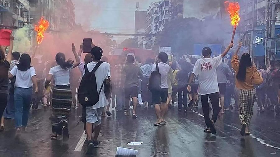 Protesters march with flaming torches as they take part in a demonstration against the military coup in Yangon. Credit: AFP Photo