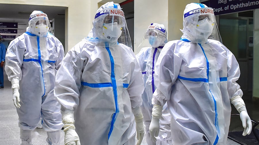Nurses walk towards a Covid-19 ward to attend to patients at Ramaiah Medical College hospital in Bengaluru. Credit: PTI Photo